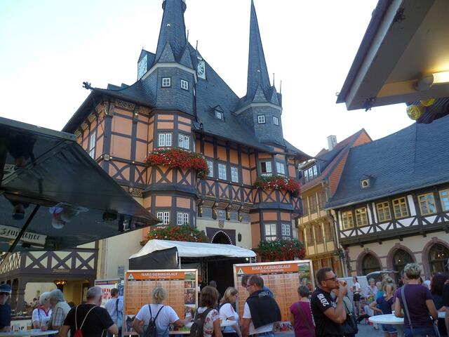 Vor dem Rathaus Wernigerode findet eine Pasta-Party mit Geigenspiel statt. Die Tafeln erinnern an Sieger und Bestzeiten aus der Geschichte des HGL.