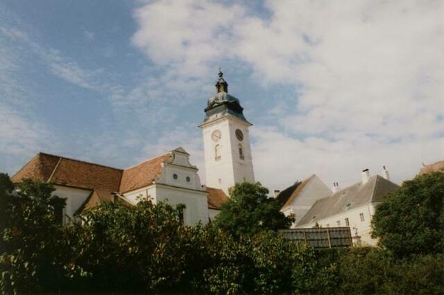 Beginn des Schulgeländes. Blick zum Lehrerparkplatz, zum Fahrraddach und zur Retzer Stadtpfarrirche. Aufnahme aus dem Frühjahr.