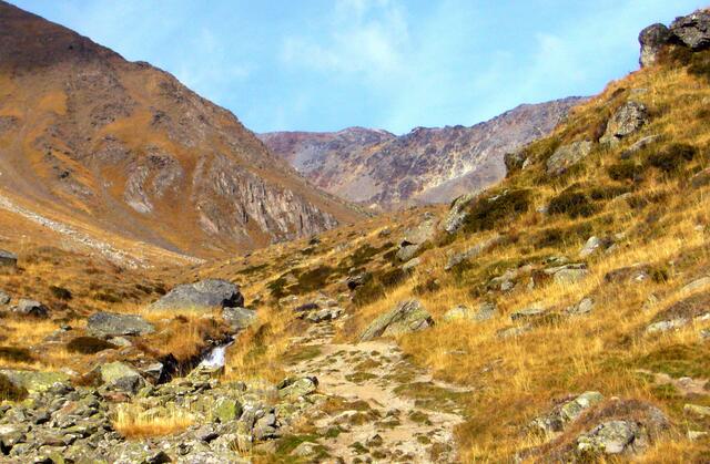Hoch oben ist die kleine Senke des Tisenjochs erkennbar, das früher wie heute einen Übergang zu den Ötztaler Alpen bildet. Sogar das Denkmal, das an der Fundstelle der Eismumie steht.