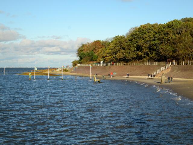 Der Badestrand des Nordseebades Dangast in herbstlicher Abendsonne. Eckart Grenzer errichtete 1984 seine 4,6 Tonnen schwere Skulptur „Grenzstein“, die heute unter "Der Phallus" bekannt ist. Direkt an der Hochwassergrenze aufgestellt (Dem Land das Meer – Dem Meer das Land), versinnbildlicht das Meer das weibliche Element – demnach das Land das männliche. So kommt es durch die Gezeiten zur Begegnung oder Umarmung der Geschlechter. Rechts steht der Phallus jetzt wieder trocken.