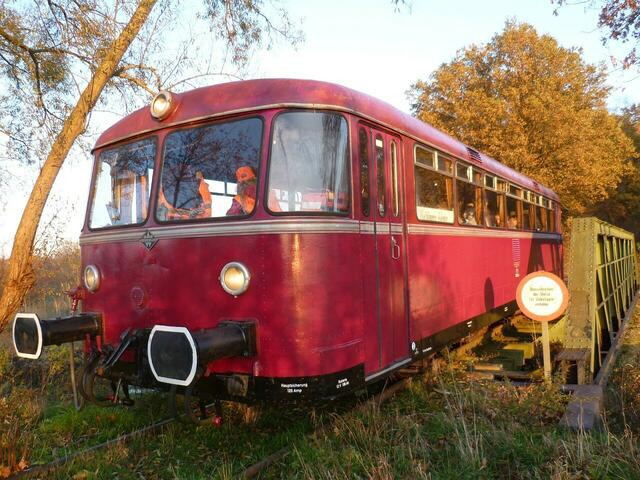 Ein schönes Bild: Der Schienenbus - in  der Bundesbahn typischen Farbe für Triebwagen Purpurrot - und der Herbstwald.