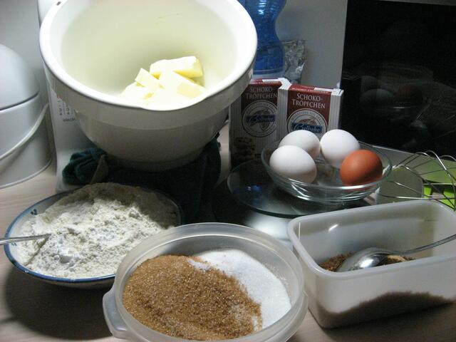 Butter, Eier, weißer und brauner Zucker, Mehl mit Backpulver, geröstete Mandeln, zwei Päckchen  Schokotröpfchen.... alles liegt griffbereit. Das Rühren übernimmt die Küchenmaschine.