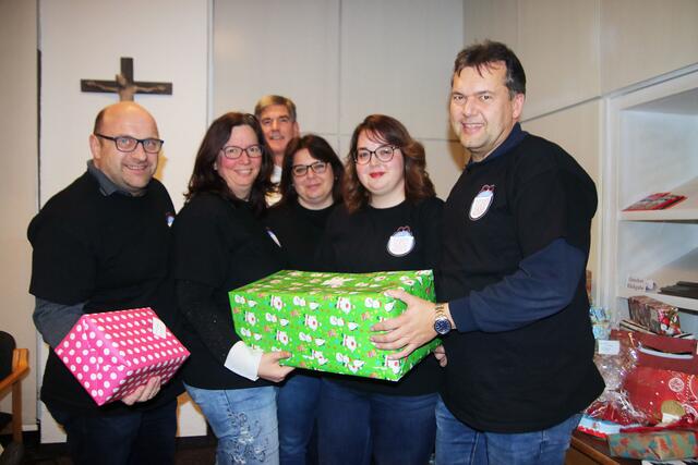 (von links) Günter Bugar, Tanja Schnepp, Yvonne Reutemann, Sophia Meneghini und Andreas Schnepp vom Verein Kinderweihnachtswunsch freuen sich mit Ulrich Lorenz, der Gesamtleiter der Kinder- Jugend- und Familienhilfe Hochzoll (hinten) über die Geschenke für die Kinder und Jugendlichen.