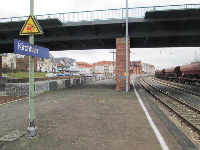 Bahnhof Kirchhain. Das Bahnhofsgebäude selbst ist das rote Haus rechts hinter dem Brückenpfeiler.