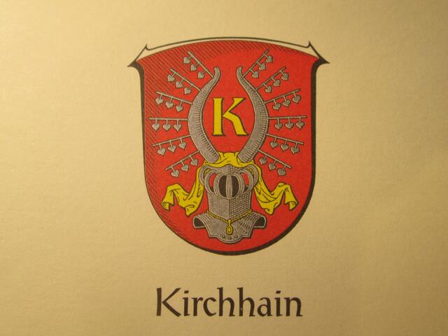 Am 11. 11.1986 erteilte das Land Hessen der Stadt Kirchhain die Genehmigung, das nachstehend beschriebene Wappen zu führen:
"Das Wappen der Stadt Kirchhain zeigt im roten Schilde einen silbernen Spangenhelm mit goldenen Helmdecken und zwei silbernen Büffelhörnern als Helmzier, die außen mit je sechs silbernen Lindenzweigen besteckt sind, zwischen den Büffelhörnern ein goldenes K."