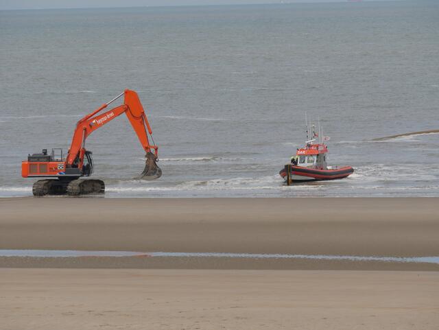 Bagger und Boot nähern sich an