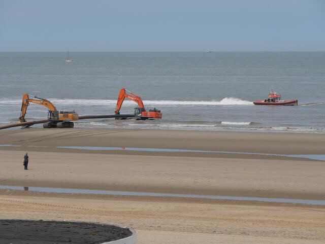 Das Rohr ist jetzt in sicheren Schaufeln. Die Bagger fahren es zurück ins Wasser