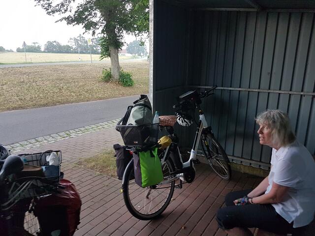 Regenschauer abwarten: Im Buswartehäuschen - Eintritt in den ADFC mit Rabatt-Code: https://www.adfc.de/formulare/beitrittserklaerung-fuer-einstiegsmitglieder/?aktionscode=62-F21