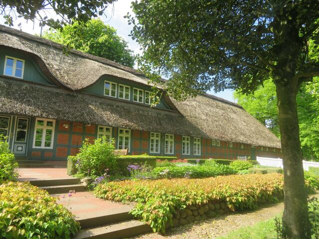 Ein großes mit Reet gedecktes Haus.