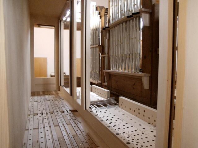 Blick ins Orgelinnere: Rechts die Rückseite der Prospektpfeifen, dahinter zwei Pfeifenstöcke, ganz hinten die Lochleisten, welche die Windversorgung der darüber zu montierenden Register steuern werden.