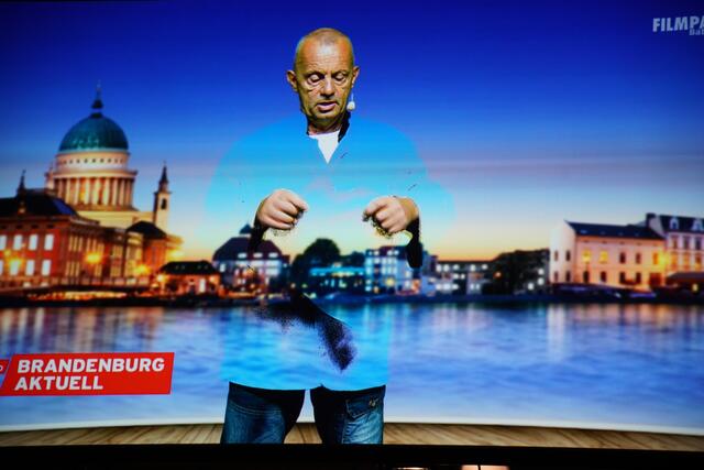 Der Moderator zeigt sich teilweise versteckt im Bluescreen