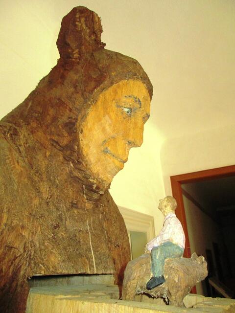 Johannes Hepp (Freiburg) und der "Mann im Bärenkostüm". Auf einer Schublade reitet ein Mann rittlings auf einem Bären. Dieses Werk stammt aus der Anstoßphase des Battenberger Kunstwegs.