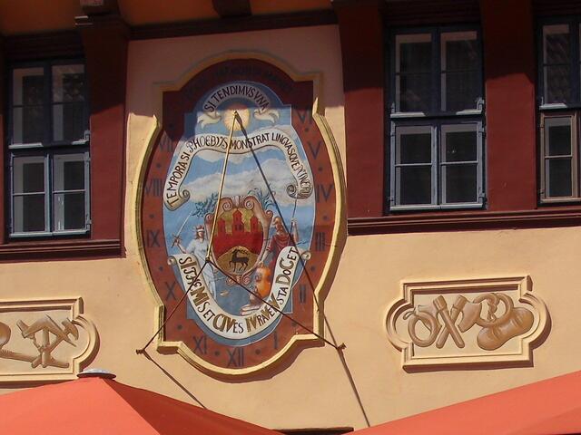 . . . die Sonnenuhr auf dem Emblem am Rathaus zeigt  die " mitteleuropäische Zeit " an , . . .14.15 Uhr . . .