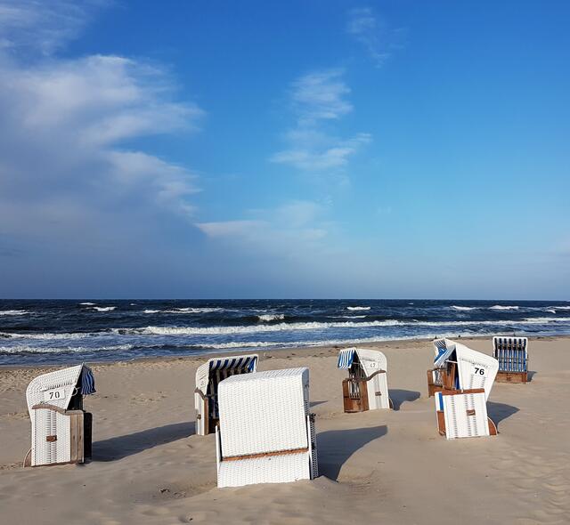 Korbkreis. Menschenleeres Strandstück im sommerlichen Sonnenschein.