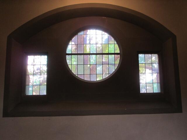 Blick aus dem Kircheninneren auf die Bäume neben der Kirche.