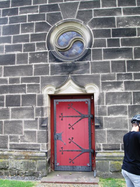Ein Seitenausgang mit einem Ornament, das die Ewigkeit symbolisiert.