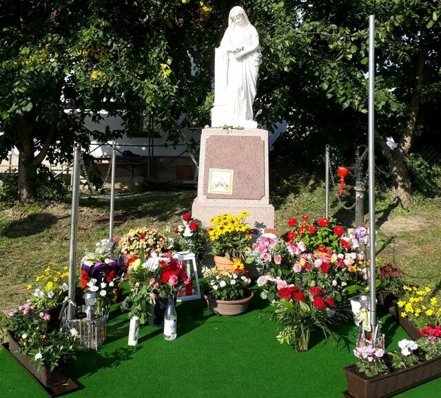 Blumenspenden der PilgerInnen an der Marienstatue
