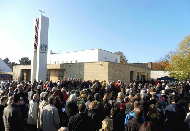 Eine große Menschenmenge "schiebt" sich in das neue Kirchen-Gebäude...