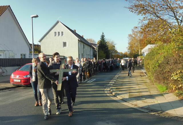 Die Prozession erreicht die Kreuzung Einsteinstraße/Hartenbrakenstraße. Im Hintergrund rechts, fast verdeckt, ist der alte Kirchsaal zu sehen.