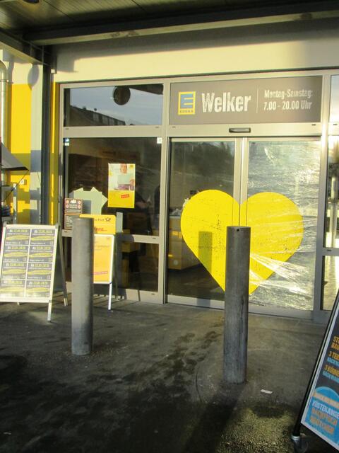 Eingang zum EDEKA-Markt Welker. Hinter der Eingangstür links ist die Postfiliale.
