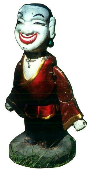 Eine glücklich strahlende vietnamesische Puppe wird auf dem Wasser von Teichen und Flüssen  unsichtbar unter Wasser von Schauspielern bewegt.