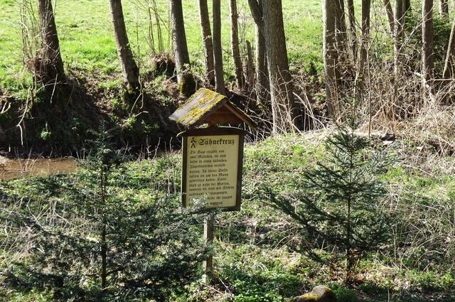 am Sühnekreuz, direkt dahinter fließt die Eine. Das Sühnekreuz soll früher einige Meter weiter auf einer Wiese gestanden haben.
