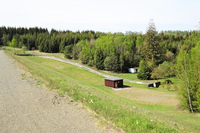 Die Luftseite des Staudamms Teufelsteich mit Schieberhaus und dem Hochwasserentlastungsgraben