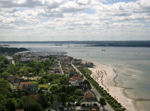 Blick über Laboe bis nach Kiel. Mittig gesehen fährt ein Schiff vor Kiel-Holtenau in den Nord-Ostsee-Kanal.