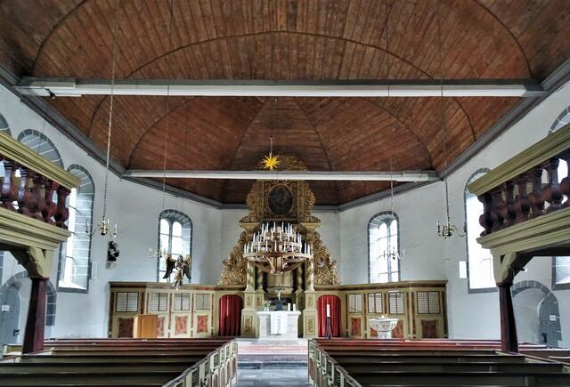St. Georg Kirche mit gewölbter Holzdecke(Tonnengewölbe). Der Leuchter ist mit echten Kerzen ausgerüstet, für das handling kann, über eine Seilwinde, der Leuchter abgesenkt werden