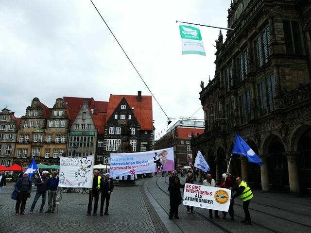 Vertreter des Bremer Friedensforums und der Ärzteorganisation IPPNW trafen sich auf dem Marktplatz, um die Beflaggung des Rathauses mit Transparenten zu unterstreichen.