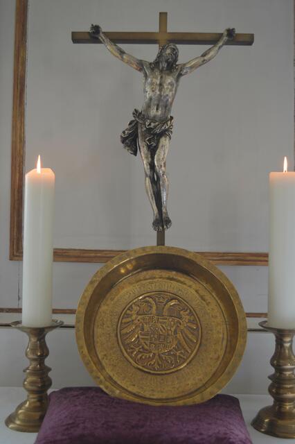 Das Kruzifix auf dem Altar mit der Taufschale.