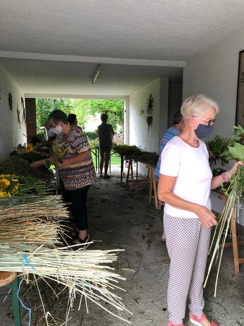 Vorbildlich nach den Vorschriften zu Corona: Binden der Blumensträuße für die Muttergottes mit Mund-Nasen-Schutz.