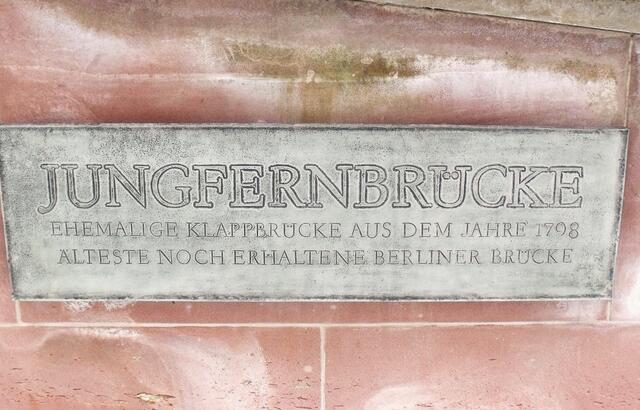 Die wahrscheinlichste Erklärung zur Herkunft des Namens betrifft zwei „Fräuleins“, die im nahe gelegenen Gasthaus „Französischer Hof“ wohnten und ihre feinen Handarbeiten in einer kleinen Verkaufseinrichtung neben dieser Brücke anboten. Die Berliner bezeichneten die fremden Damen kurzerhand als „Jungfern“, man ging also zu den Jungfern an der Brücke um Accessoires einzukaufen.