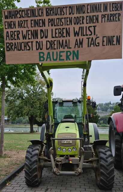 Traktor mit Protesthinweis auf das tägliche Bedürfnis an Bauern