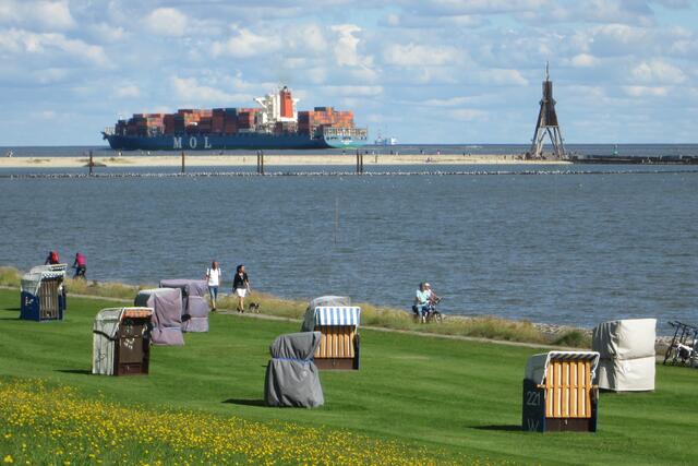 Blick über die Grimmershörnbucht auf den Weltschifffahrtsweg an der Kugelbake. Das Schiff könnte die MOL Tribute sein, ein Containerschiff der japanischen Reederei MOL Mitsui O.S.K. Lines.