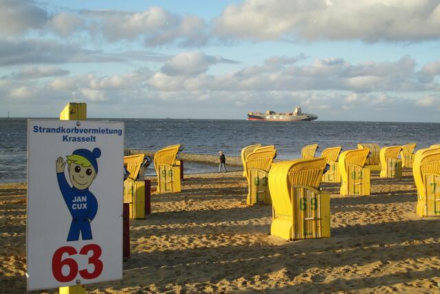 Abendschatten am Strand mit dem Blick auf den Weltschifffahrtsweg bei Cuxhaven. Im Bild ein Schiff der Mediterranean Shipping Company (MSC).