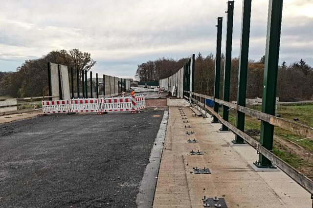 Hergestellt werden müssen lediglich noch die kurzen bituminösen Fahrbahnanschlußstücke rechts und links der Brücke. Außerdem müssen noch einige Fertigbetonteile des Wildschutzzaunes montiert werden.