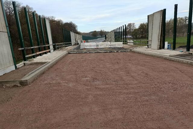 Hergestellt werden müssen lediglich noch die kurzen bituminösen Fahrbahnanschlußstücke rechts und links der Brücke. Außerdem müssen noch einige Fertigbetonteile des Wildschutzzaunes montiert werden.