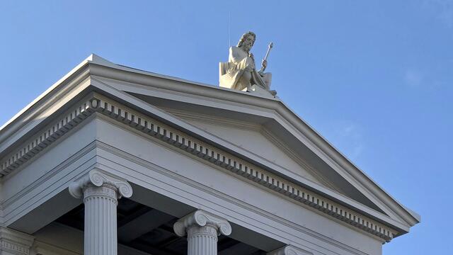 Vom Giebel der denkmalgeschützten Staatskanzlei schaut die Götterfigur Zeus auf die Schlossstraße herab. Symbolisch steht Zeus aus der griechischen Mythologie für eine umfassende Staatsgewalt. Der Bildhauer Emil Cauer schuf die Sandsteinskulptur. Foto: Helmut Kuzina