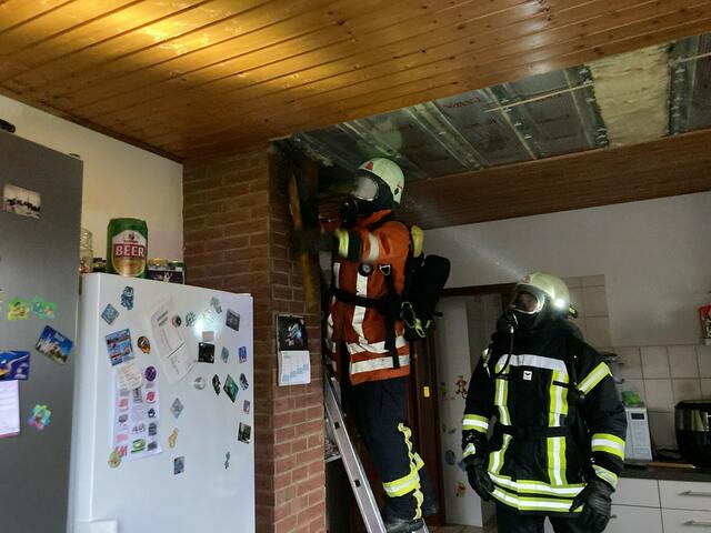 Öffnung der Deckenkonstruktion am Schornstein durch Einsatzkräfte im Innenangriff unter Atemschutz