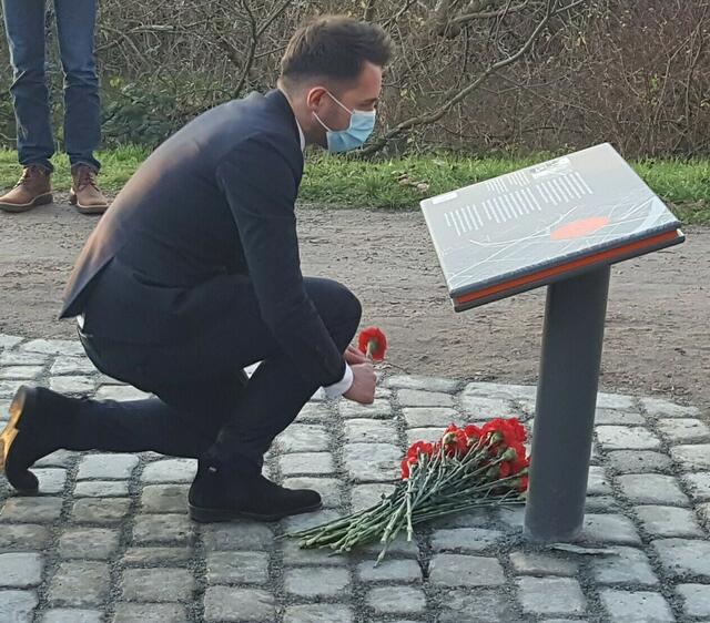 Vizekonsul Mikhail Marin, Generalkonsulat der Russischen Föderation in Hamburg, verneigt sich an der neuen Erinnerungsstätte und legt einen großen Blumenstrauß nieder.