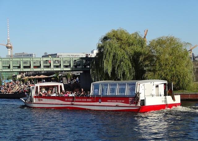 Ausflugsboot vor der Gustav-Heinemann-Brücke: Fußgängerbrücke über die Spree zwischen Hauptbahnhof und Regierungsviertel. Der Brückenbelag musste mehrmals geändert werden, da er für Stöckelschuhe nicht geeignet war und einige Damen sich beschwerten.