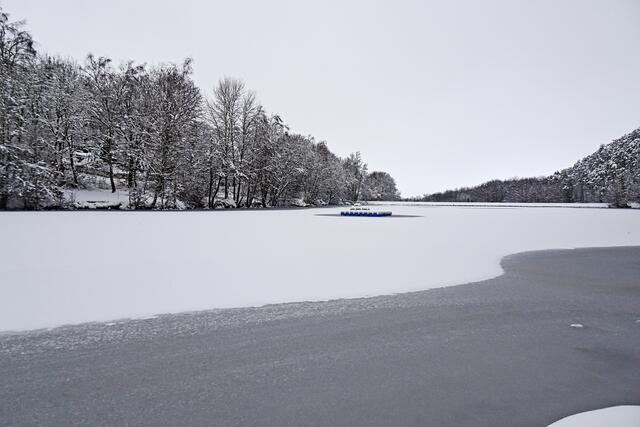 der Osterteich ist durch den durchfließenden Wellenbach ungleichmäßig zugefroren.  Da die Teichmitte bereits zugefroren war , konnte sich dort der Schnee ablagern.