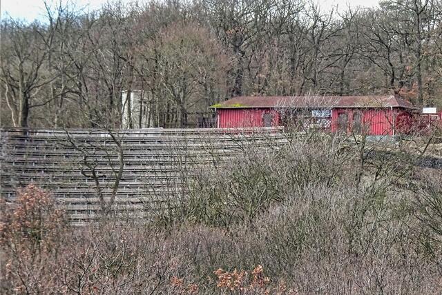 Blick von dem Pionierstieg auf ein Teil der Sitzreihen des Bergtheaters, das rote Gebäude ist der Eingang zum Bergtheater