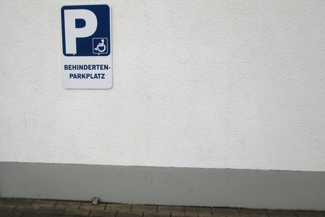 Auf dem Lidl-Parkplatz in Battenfeld wartet er unter dem Hinweisschild für den Behinderten-Parkplatz auf die Sonne und seine weitere Wanderung.