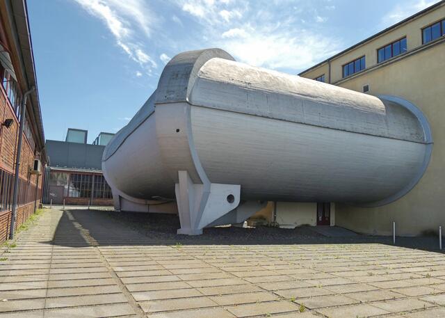 Der 130 Meter lange Große Windkanal von der Straße "Zum Trudelturm" aus gesehen. Wegen seiner futuristischen Architektur diente er als Kulisse zum Film Æon Flux (2005), der 400 Jahre in der Zukunft spielt. Zahlreiche Szenen wurden dabei im Inneren der Röhre bzw. im Innenraum des Windkanals gedreht. Weitere Produktionen, wie z.B. der Actionfilm Wer ist Hanna? (2011), nutzten den Windkanal ebenfalls als Kulisse.