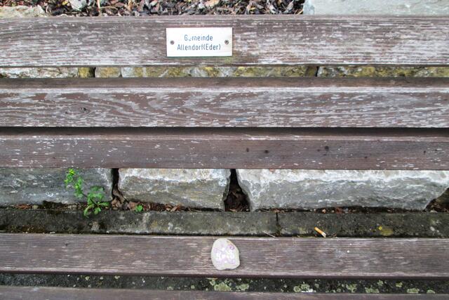 Auf einer Ruhebank der Gemeinde Allendorf in der Heinrich-Lenz-Straße am Abzweig Kleeacker wartet der Eggestone auf seine weitere Wanderung.