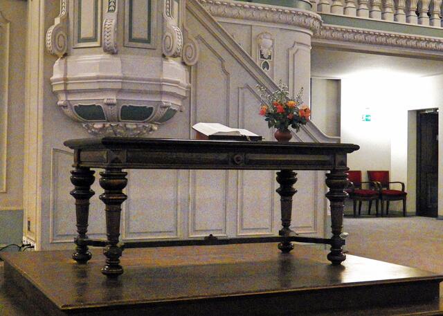 Ein einfacher Abendmahlstisch mit der Bibel, einen Altar gibt es nicht, ebenso kein Kreuz.