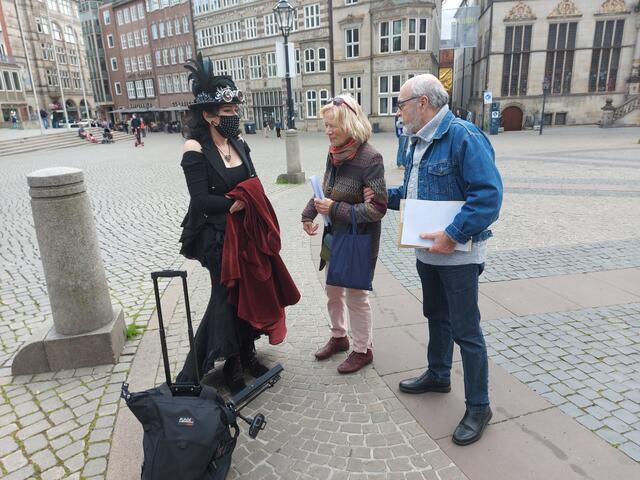 Vorbereitungsgespräch auf dem Bremer Marktplatz: Geigerin Lina Dobrnina, Irene Baumann vom Verein "Deutsch-Russische Friedenstage Bremen e.V." und Chorleiter (Rodina) Slava Kravets (von links).