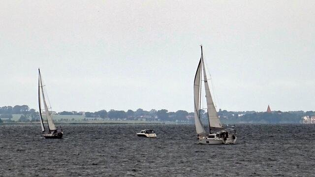 Segelboote der Ostseeregatta laufen aus der Wismarbucht aus. Im Hintergrund ist die Insel Poel mit ihrem Kirchturm zu erkennen. Foto: Helmut Kuzina